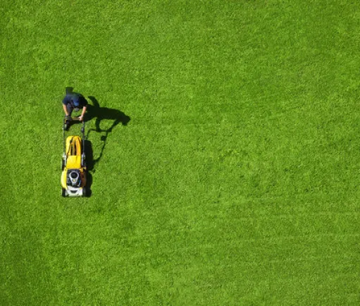 image of a landscaper mowing a garden