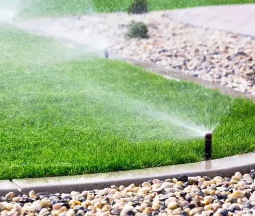 image of a running sprinkler on a green lawn